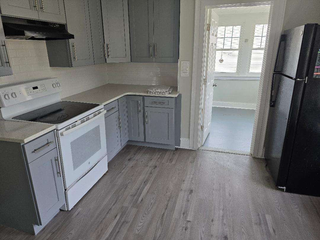 22 Holly Street Waterbury, CT 06706 - Photo 3 of 5 a kitchen with a hard wood floor white cabinets and white appliances