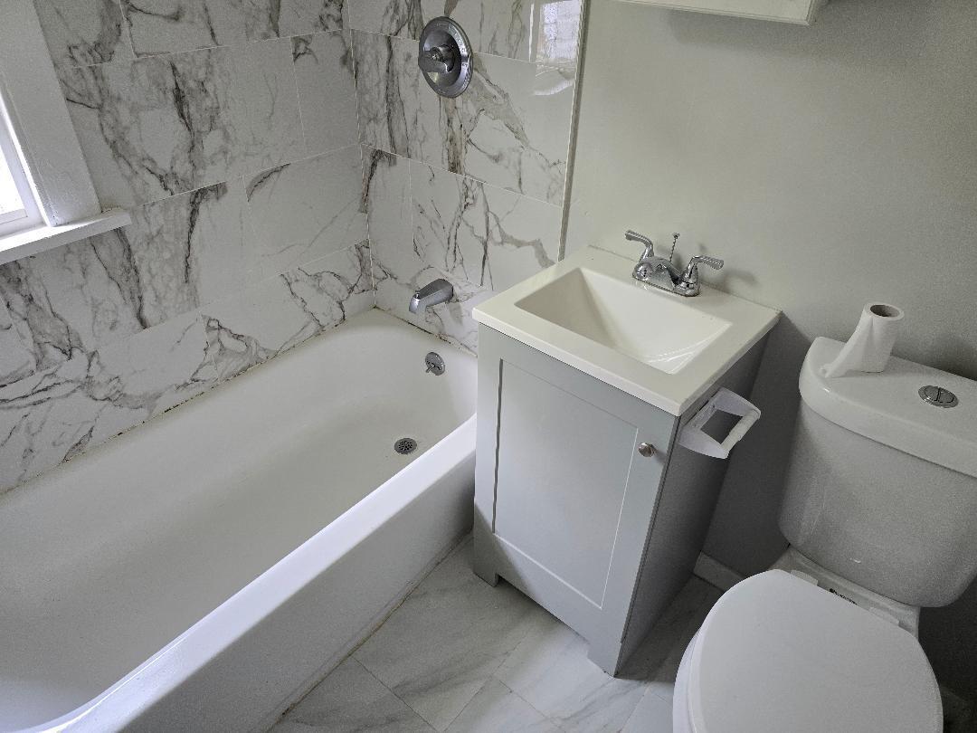 22 Holly Street Waterbury, CT 06706 - Photo 4 of 5 a white bath tub sitting next to a white toilet and sink