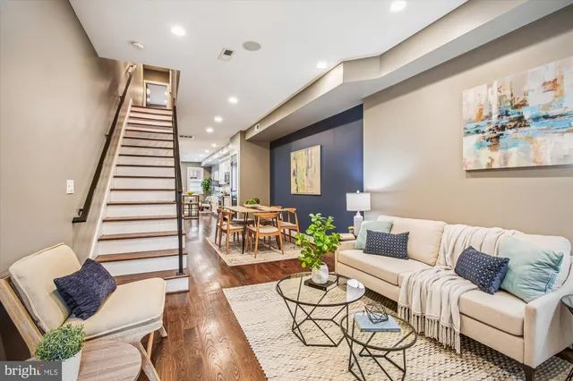 a living room with furniture and a wooden floor