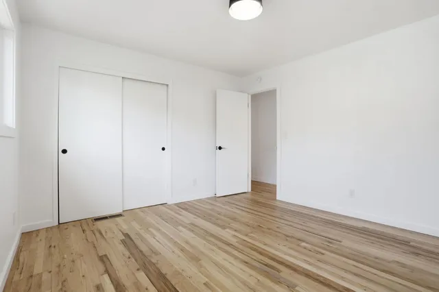 a view of empty room with wooden floor