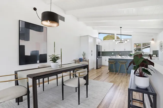a kitchen with a dining table chairs stainless steel appliances and cabinets