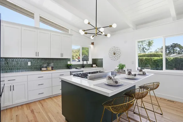 a kitchen with a table chairs and white cabinets