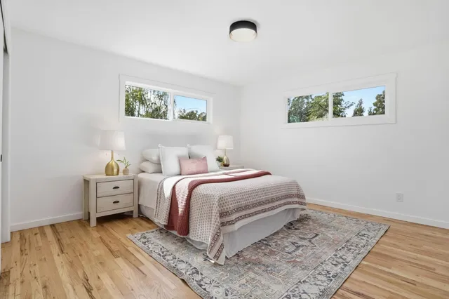 a bedroom with a bed and wooden floor