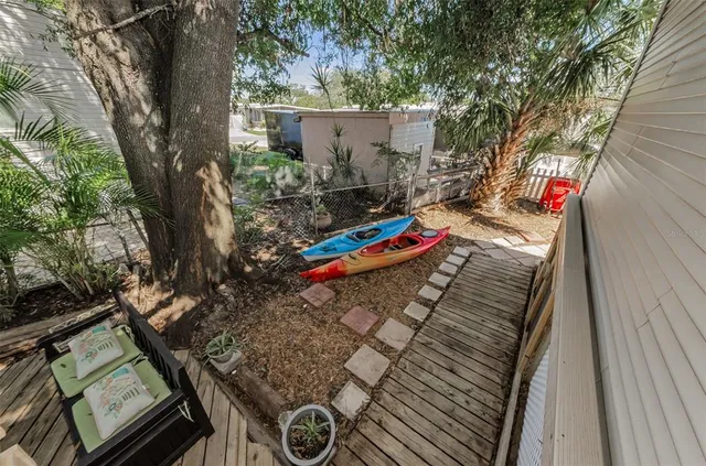 a view of a wooden door with a chair and potted plants