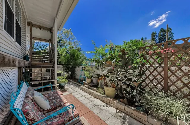 a living room with furniture kitchen view and a potted plant