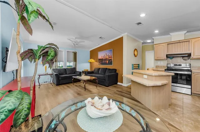 a living room with furniture a flat screen tv and floor to ceiling window