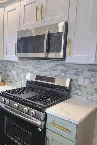 a stove top oven sitting inside of a kitchen