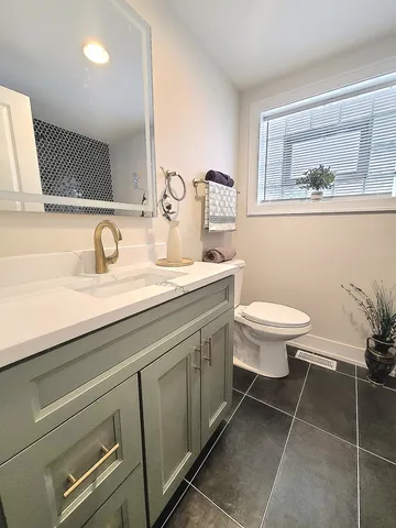a bathroom with a toilet sink and mirror