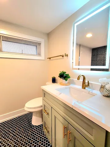 a bathroom with a sink a toilet and a mirror