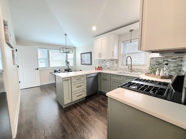 a kitchen with a sink white cabinets and white appliances
