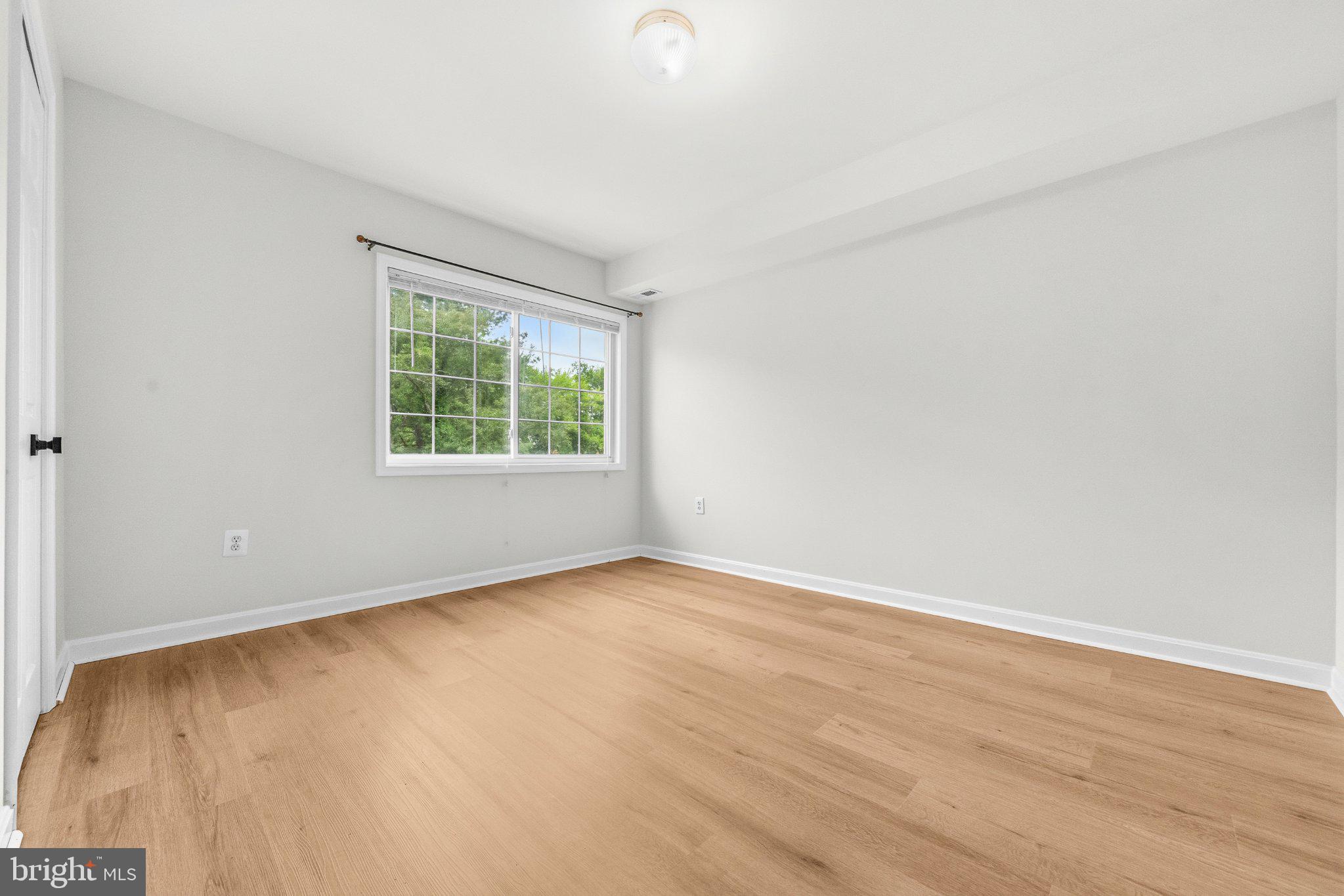635 Waterloo Road, Unit 222 Warrenton, VA 20186 - Photo 23 of 33 an empty room with wooden floor and windows