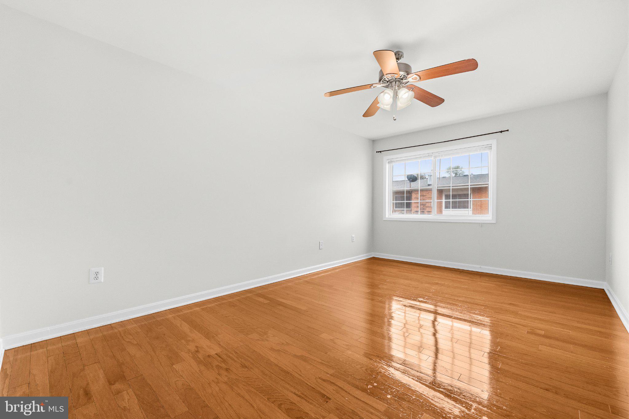 635 Waterloo Road, Unit 222 Warrenton, VA 20186 - Photo 28 of 33 a view of an empty room with wooden floor and a window