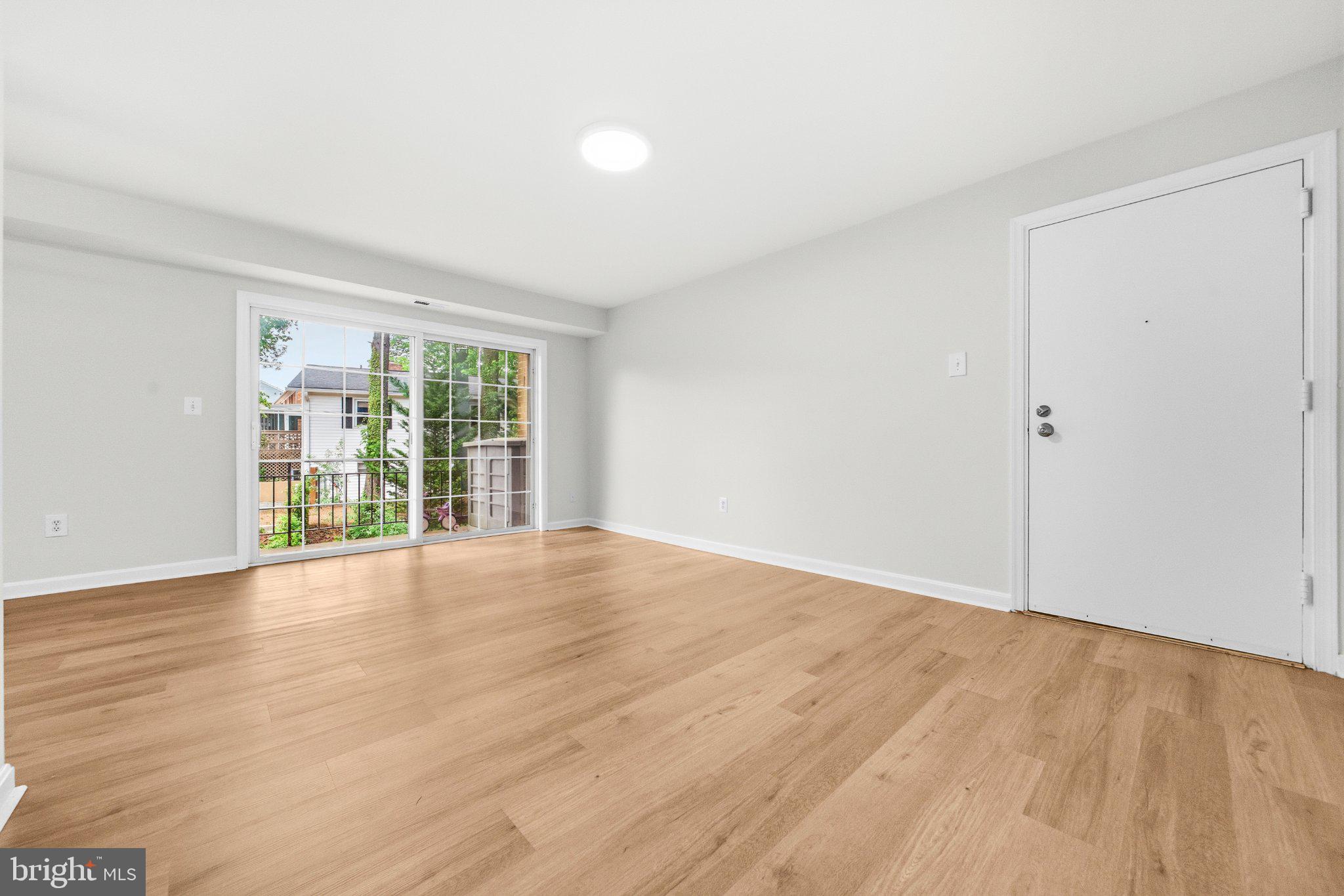 635 Waterloo Road, Unit 222 Warrenton, VA 20186 - Photo 10 of 33 a view of an empty room with wooden floor and a window