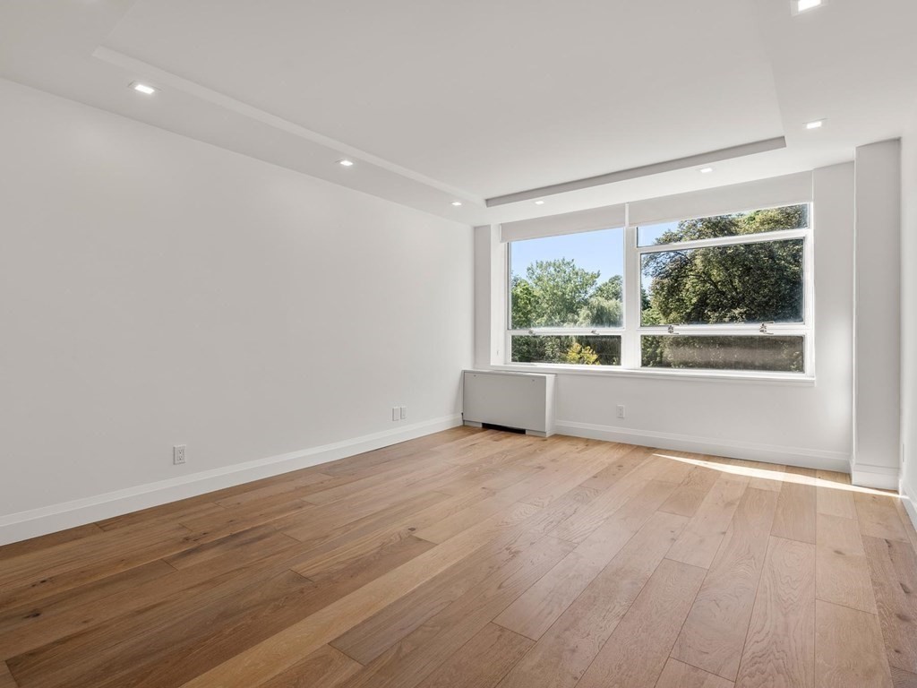 80 Park Street, Unit 24 Brookline, MA 02446 - Photo 12 of 17 a view of an empty room with wooden floor and a window