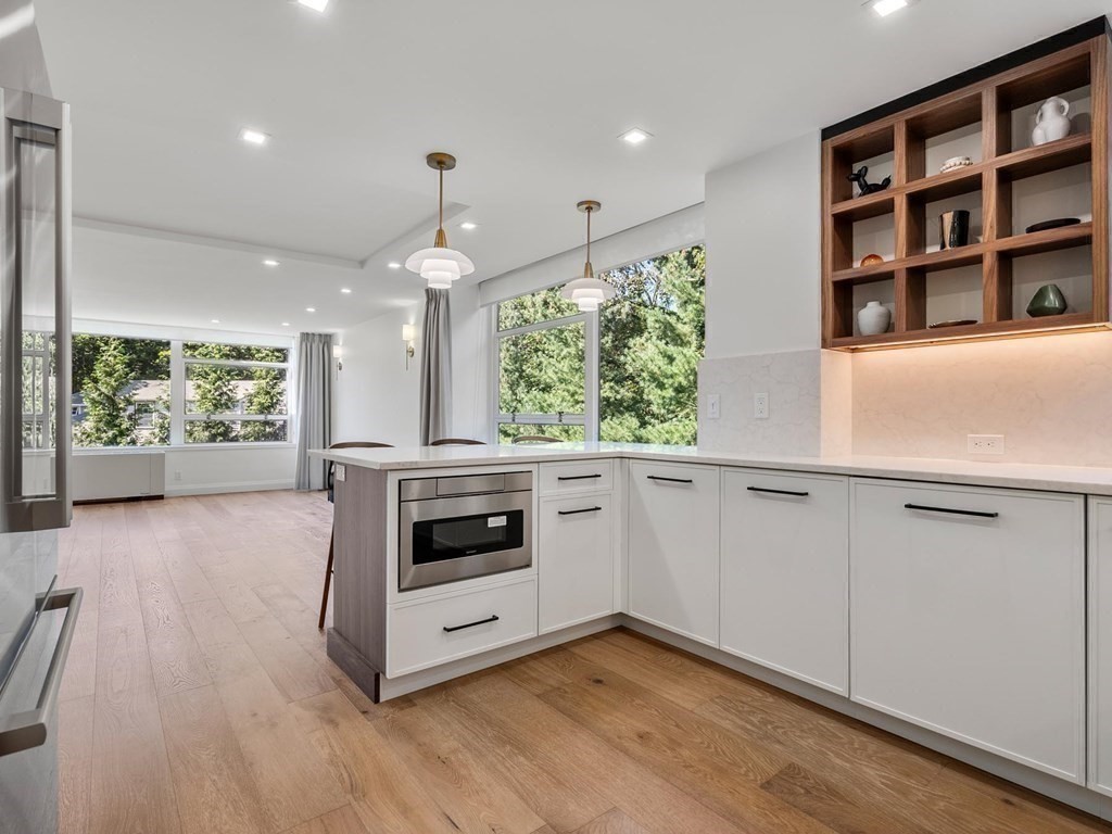 80 Park Street, Unit 24 Brookline, MA 02446 - Photo 16 of 17 a kitchen with a stove and a white countertops with wooden floor