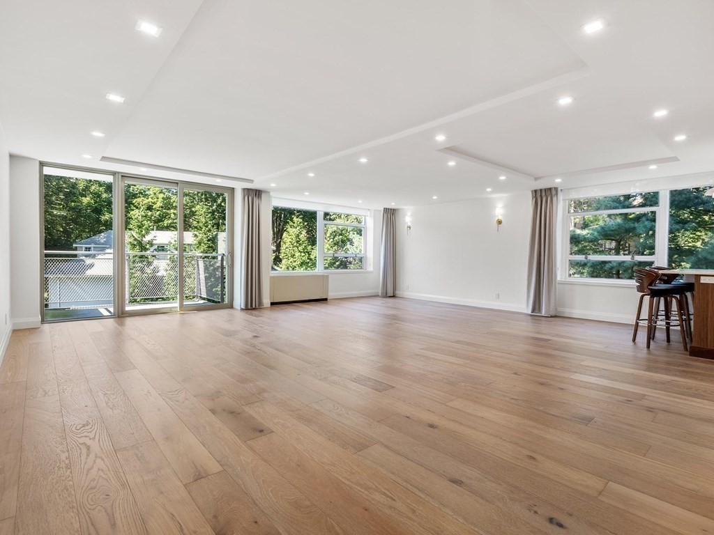 80 Park Street, Unit 24 Brookline, MA 02446 - Photo 6 of 17 a view of an empty room with wooden floor and a window