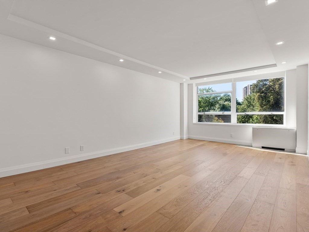 80 Park Street, Unit 24 Brookline, MA 02446 - Photo 9 of 17 a view of an empty room with wooden floor and a window