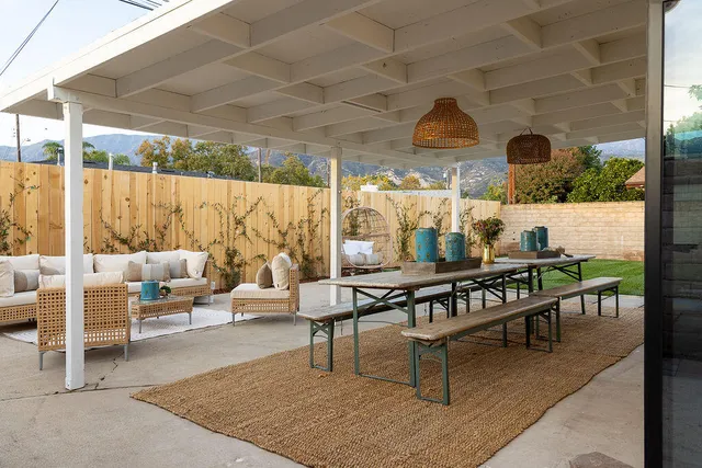 a living room with patio furniture and a floor to ceiling window