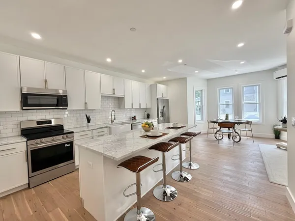 a kitchen with stainless steel appliances granite countertop a stove top oven a sink a counter space and cabinets