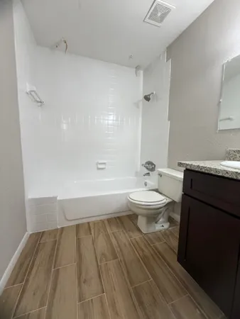 a bathroom with a granite countertop sink toilet a large mirror and shower