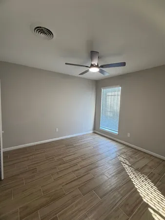 a view of empty room with wooden floor