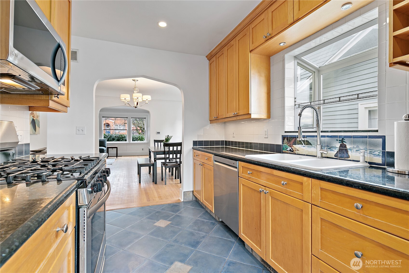 1125 North 77th Street Seattle, WA 98103 - Photo 11 of 38 a kitchen with stainless steel appliances granite countertop a stove a sink and a microwave