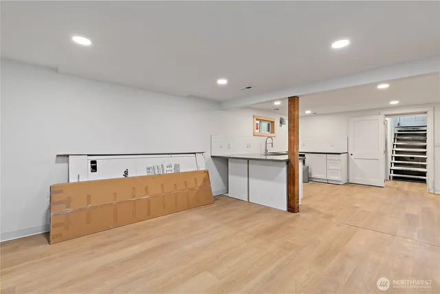 a kitchen with white cabinets and window