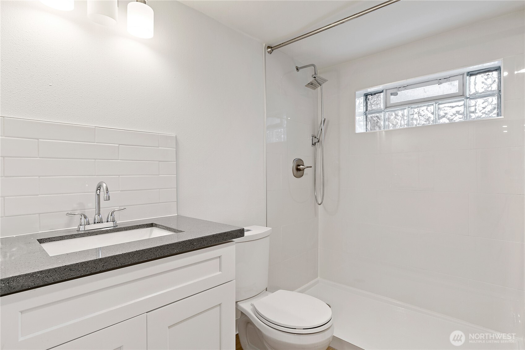 1125 North 77th Street Seattle, WA 98103 - Photo 27 of 38 a bathroom with a sink a toilet and shower