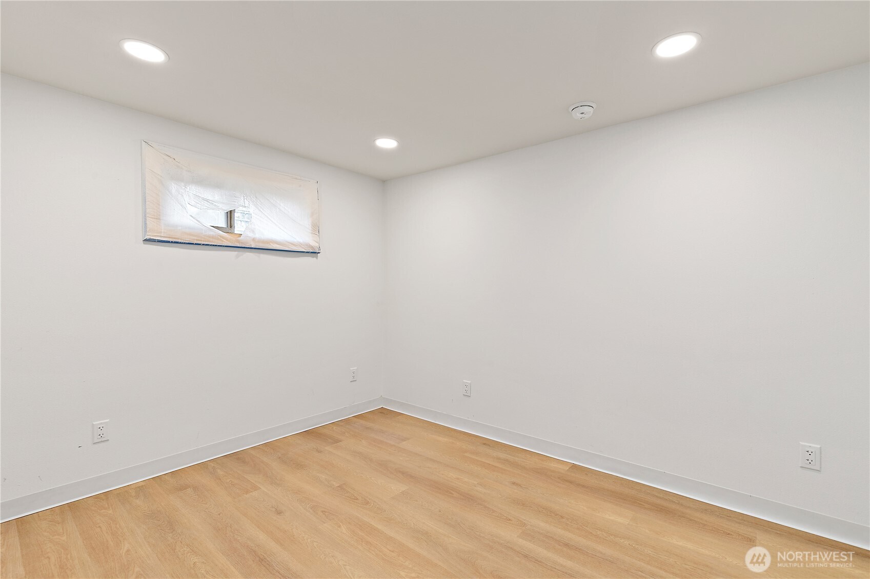 1125 North 77th Street Seattle, WA 98103 - Photo 28 of 38 an empty room with wooden floor and white walls