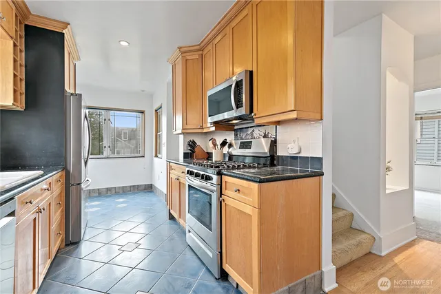 a kitchen with stainless steel appliances granite countertop a stove a sink and a microwave