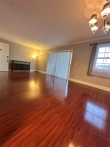 a view of a room with wooden floor and window