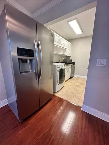 a kitchen with stainless steel appliances granite countertop a refrigerator a sink and wooden floor