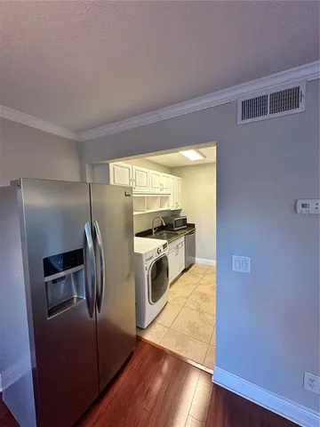 a kitchen with stainless steel appliances granite countertop a refrigerator a stove and a sink