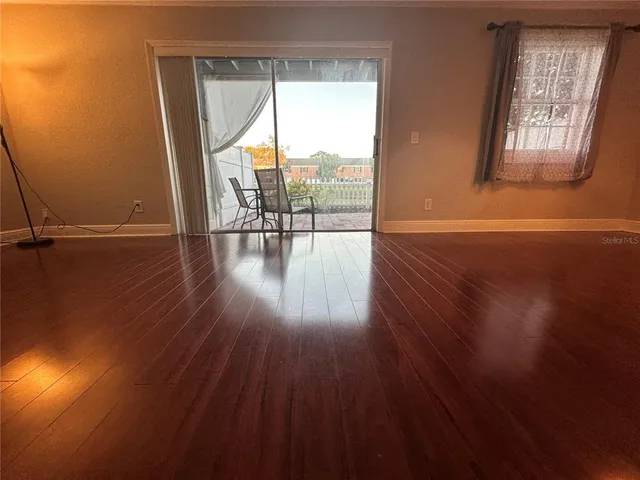 a view of a room with wooden floor and windows