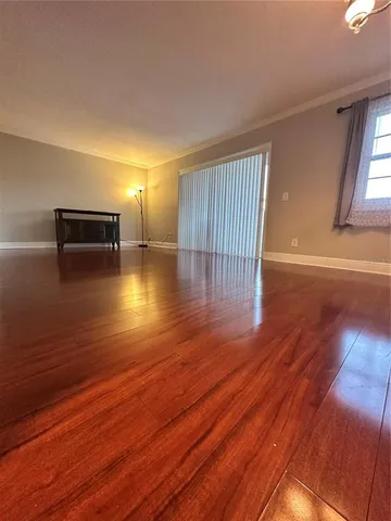 a view of empty room with wooden floor