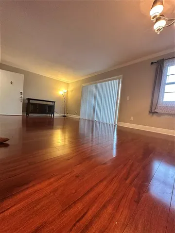 a view of empty room with wooden floor