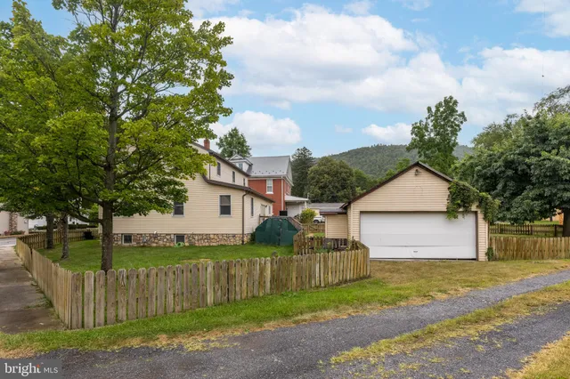 a front view of a house with a yard and trees