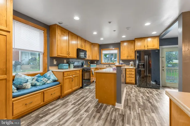 a kitchen with stainless steel appliances granite countertop a refrigerator a stove top oven and a refrigerator