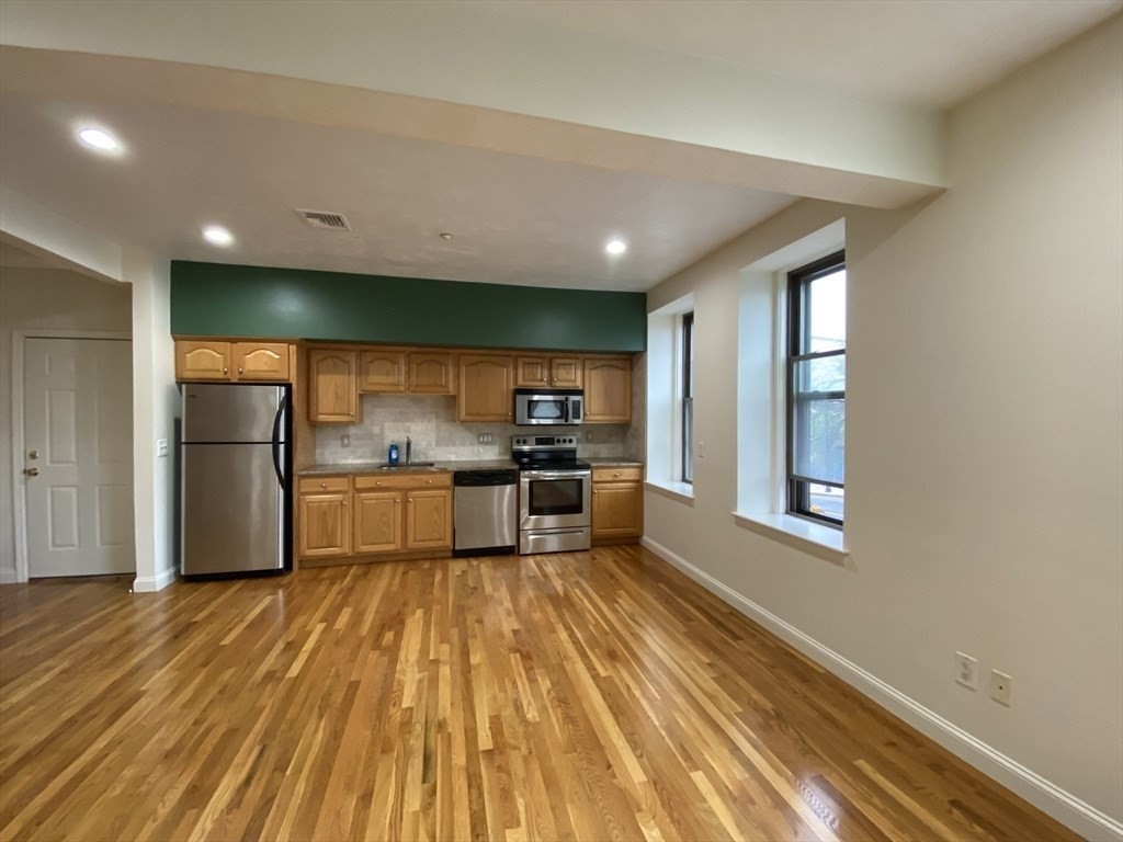 1008 Bennington Street, Unit 4A Boston, MA 02128 - Photo 2 of 9 a kitchen with a refrigerator and a sink