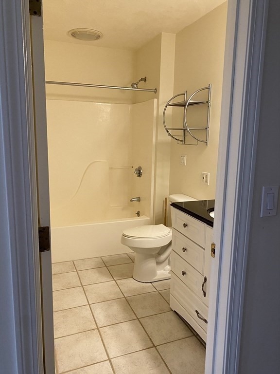 1008 Bennington Street, Unit 4A Boston, MA 02128 - Photo 9 of 9 a bathroom with a granite countertop sink toilet a mirror and shower