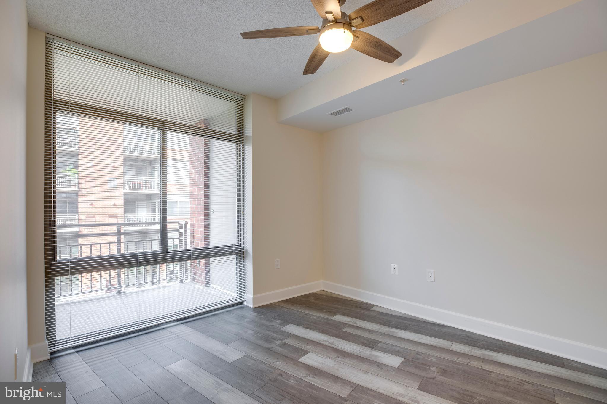3600 South Glebe Road, Unit 427W Arlington, VA 22202 - Photo 15 of 49 a view of an empty room with wooden floor and a window