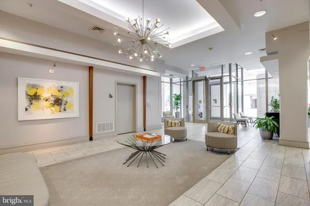 a living room with furniture and a chandelier