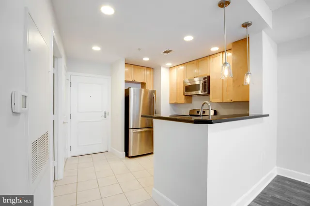 a kitchen with stainless steel appliances a refrigerator and microwave