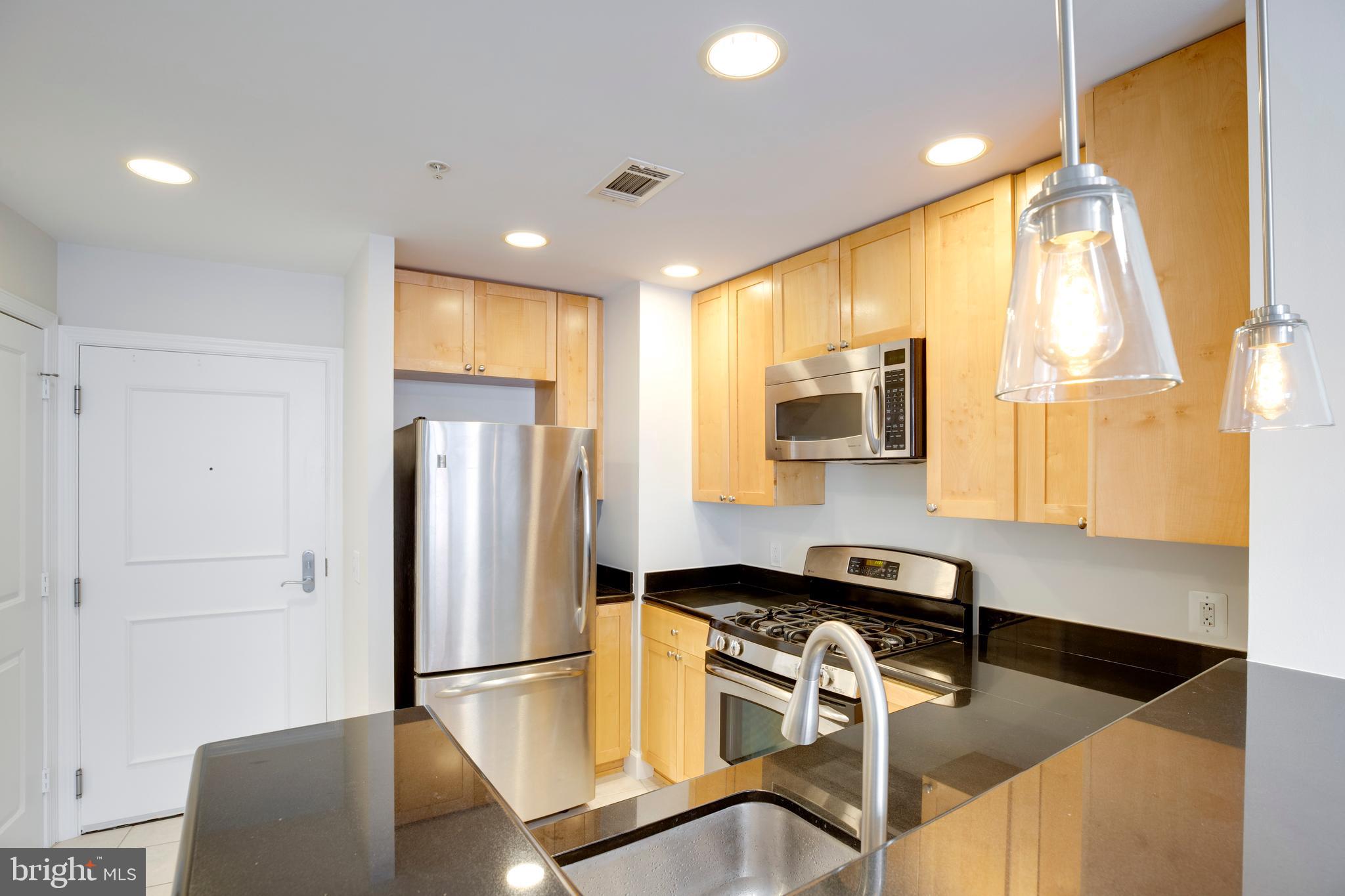 3600 South Glebe Road, Unit 427W Arlington, VA 22202 - Photo 7 of 49 a kitchen with a refrigerator a sink and a stove top oven