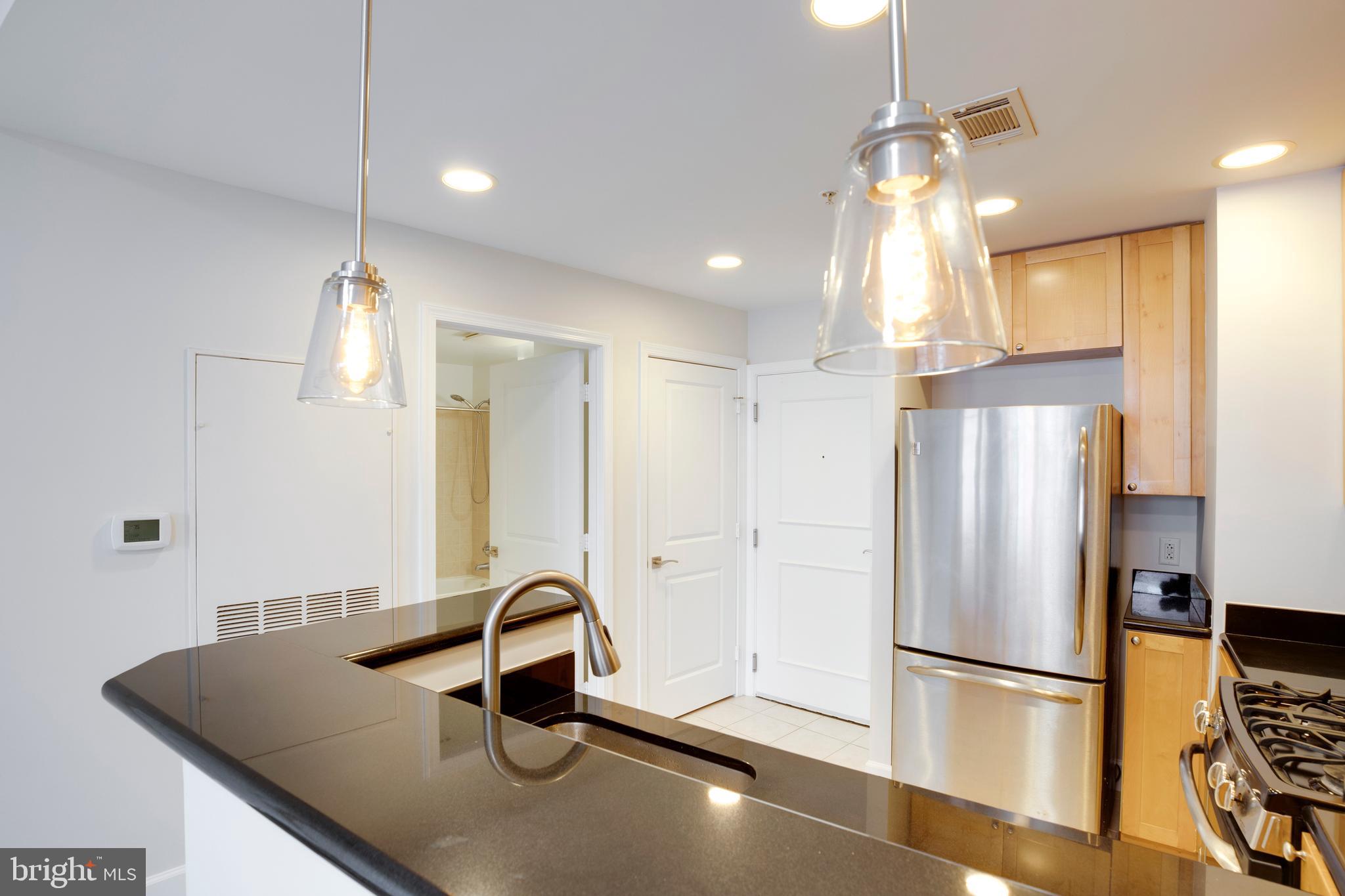 3600 South Glebe Road, Unit 427W Arlington, VA 22202 - Photo 8 of 49 a kitchen with kitchen island a refrigerator a sink and a counter top space
