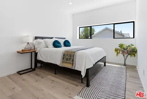 a bedroom with a bed and a potted plant