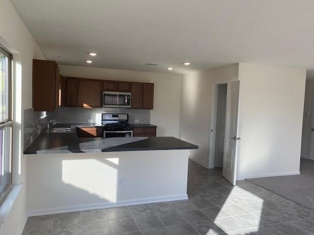 727 Hardwood Grove Houston, TX 77090 - Photo 18 of 26 a kitchen with stainless steel appliances granite countertop a sink stove and refrigerator