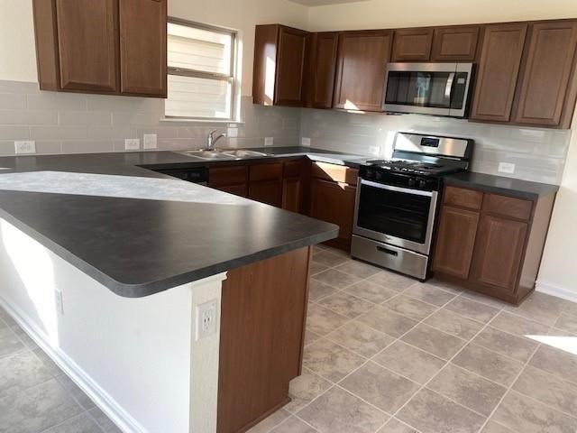 727 Hardwood Grove Houston, TX 77090 - Photo 19 of 26 a kitchen with stainless steel appliances granite countertop a sink stove and microwave