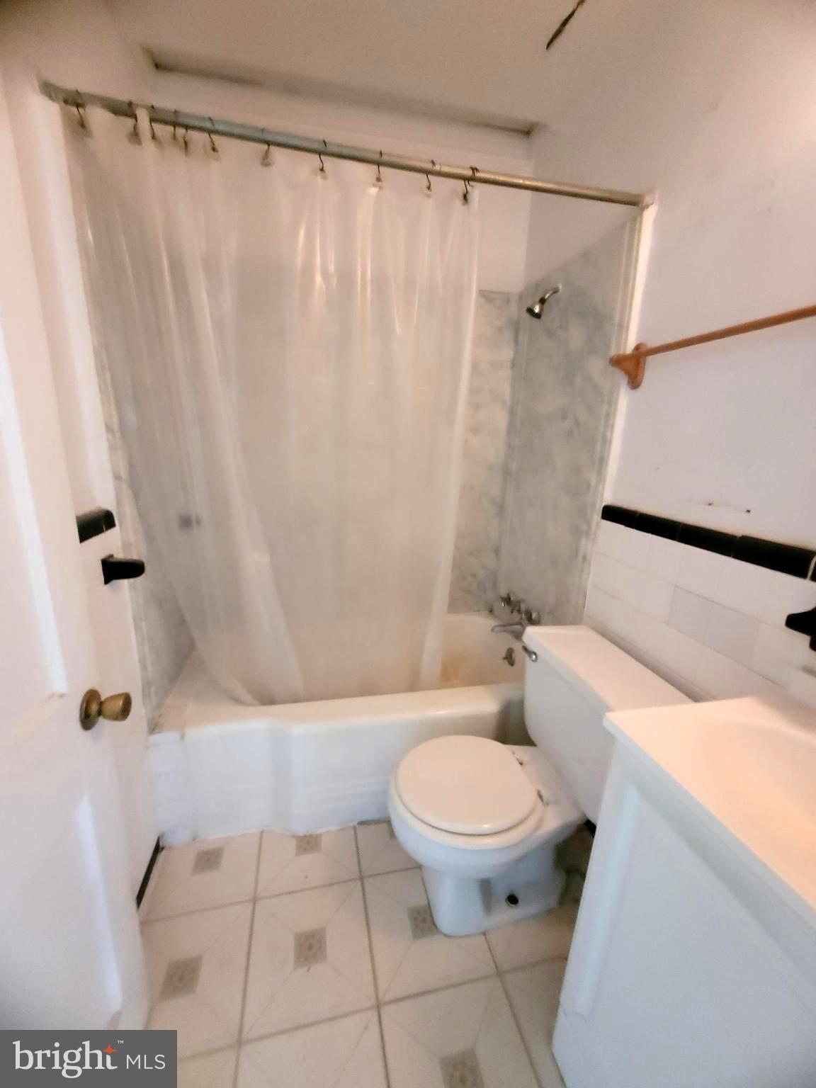 2930 Sollers Point Road Dundalk, MD 21222 - Photo 6 of 12 a bathroom with a toilet and a shower curtain