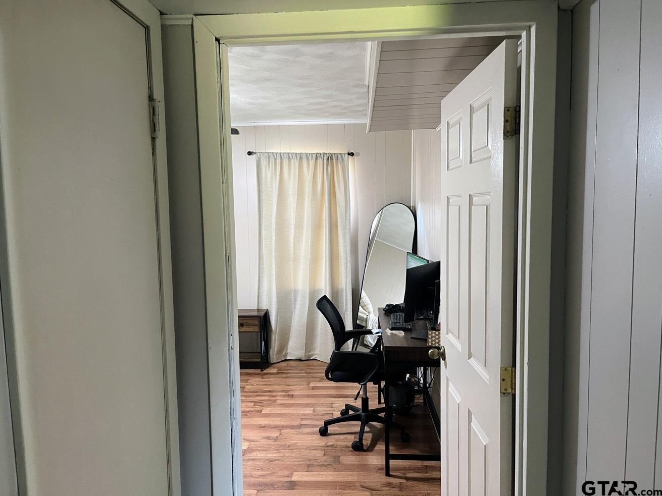 407 Fulton Street Pittsburg, TX 75686 - Photo 11 of 30 a view of a workspace room with wooden floor and windows